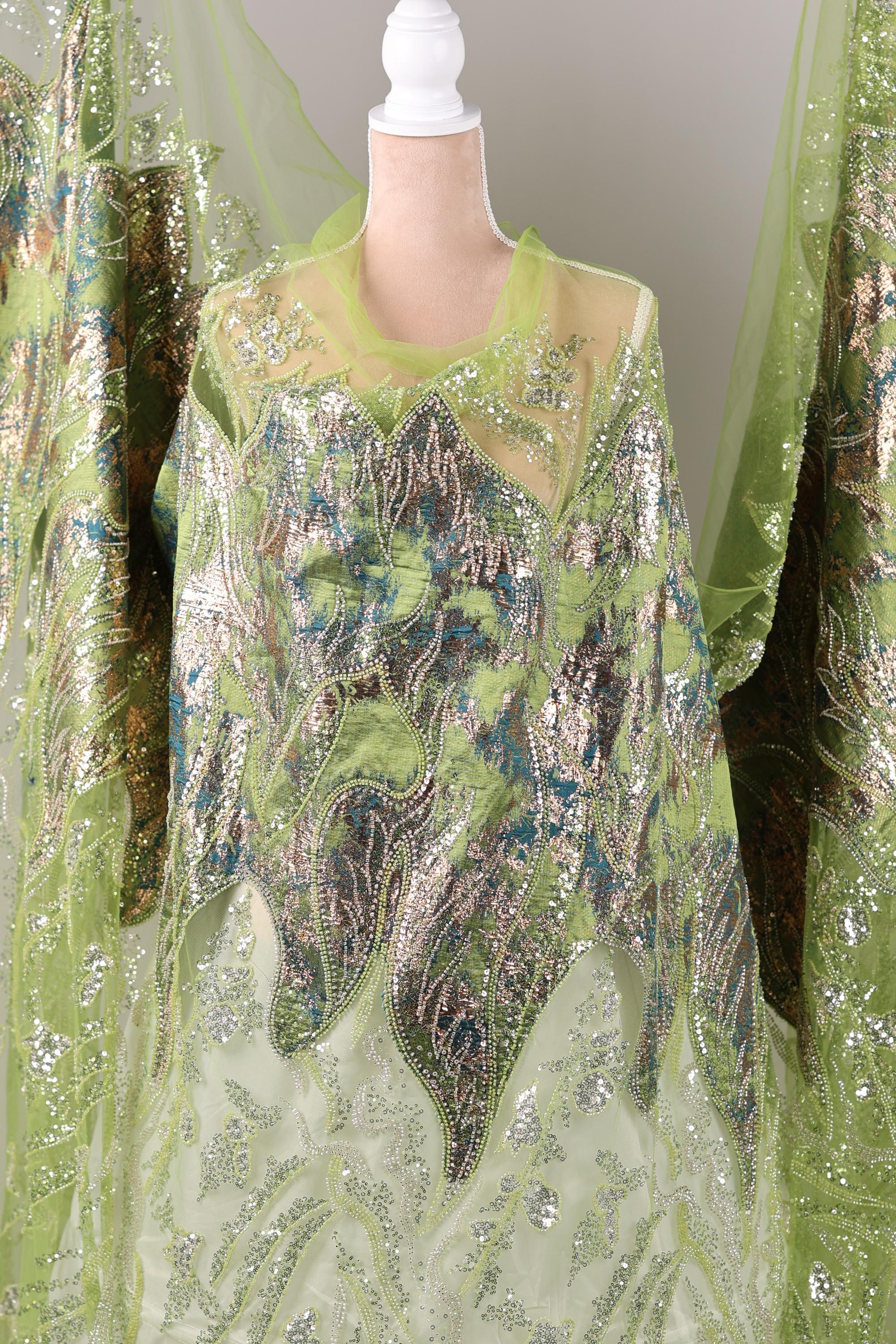 a green and silver dress with intricate embroidery and sequin details, creating a visually striking and elegant garment.