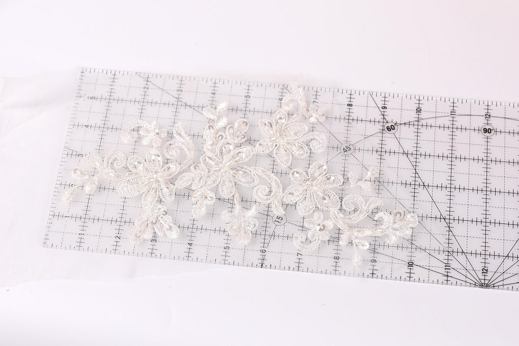 a clear ruler with a delicate white lace design placed on it.