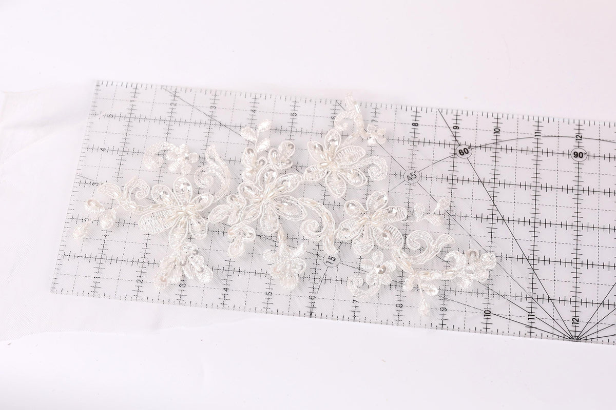 a clear ruler with a delicate white lace design placed on it.