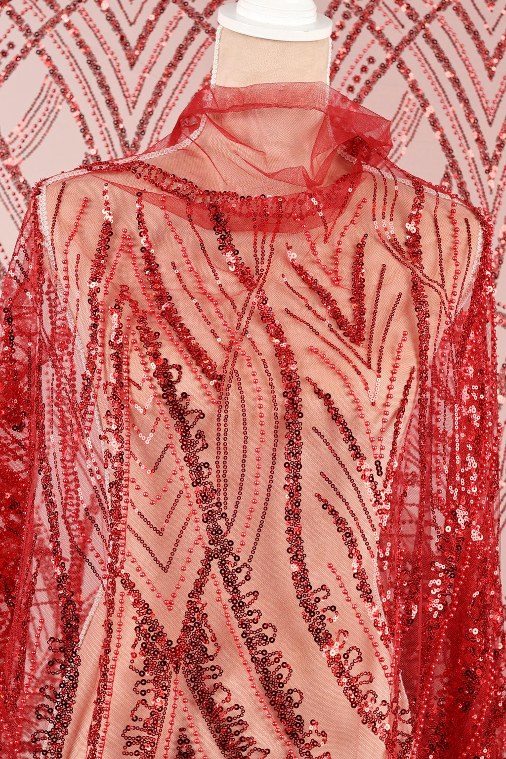a red sequin dress with a sheer overlay, showcasing a detailed and intricate pattern of red and black sequins.