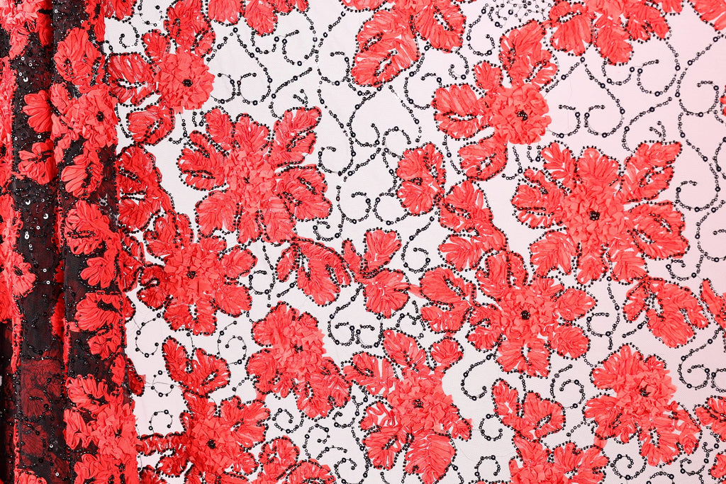 a close-up view of a fabric with a striking red floral pattern. The fabric is adorned with numerous red flowers, each with a black leaf design, creating a visually appealing contrast against the white background. The pattern is intricate and detailed, showcasing the craftsmanship involved in creating this textile.