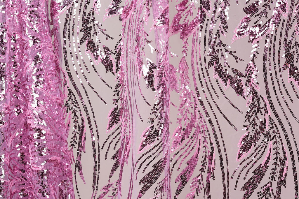 a close-up view of a fabric with a pink and purple sequin pattern. The fabric appears to be a sheer material, with the pink sequins arranged in a zigzag pattern and the purple sequins forming a repeating pattern. The fabric has a textured appearance, with the pink sequins appearing more densely packed than the purple ones. The overall design of the fabric is visually striking and eye-catching.
