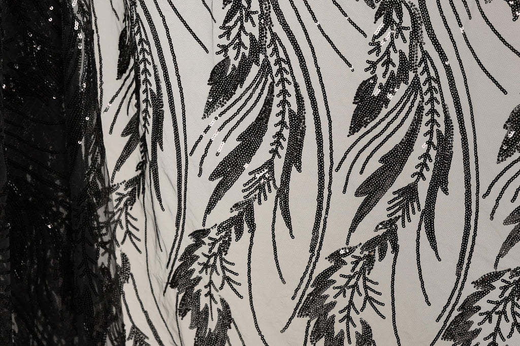 a close-up view of a fabric with a black and white pattern of sequins and lines, creating a visually striking and intricate design.