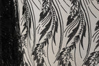 a close-up view of a fabric with a black and white pattern of sequins and lines, creating a visually striking and intricate design.