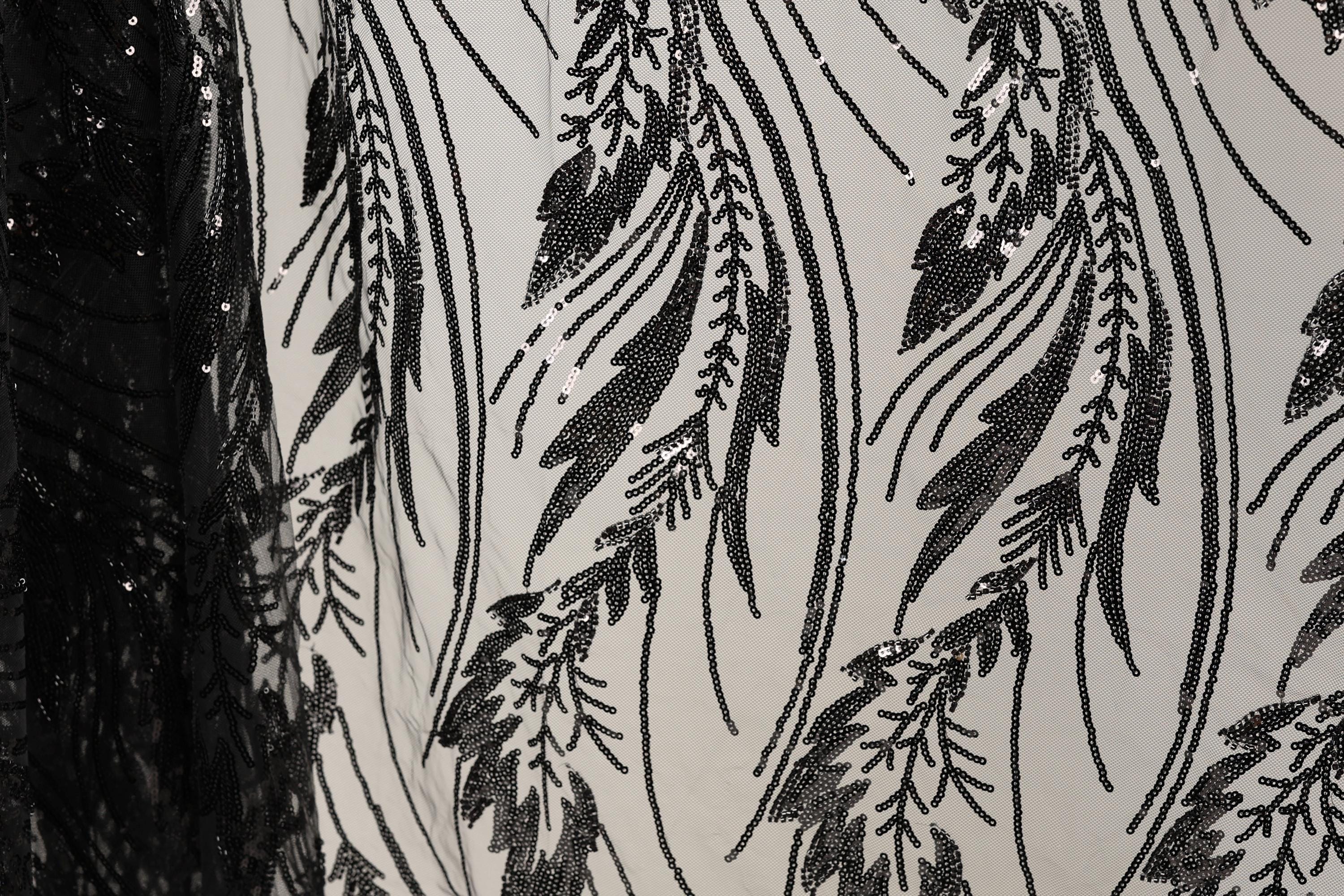 a close-up view of a fabric with a black and white pattern of sequins and lines, creating a visually striking and intricate design.