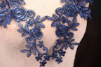 a close up of a dress with blue flowers on it