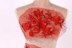 A mannequin wearing a red dress with intricate floral embroidery on the front.
