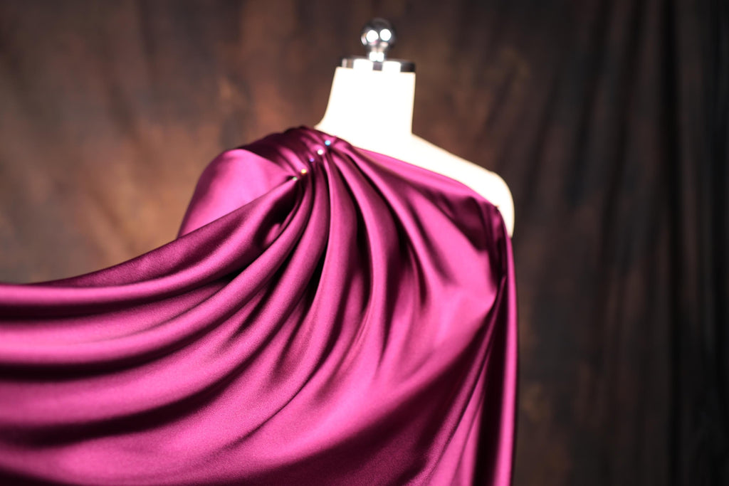 a dress on a mannequin with a purple cloth draped over it