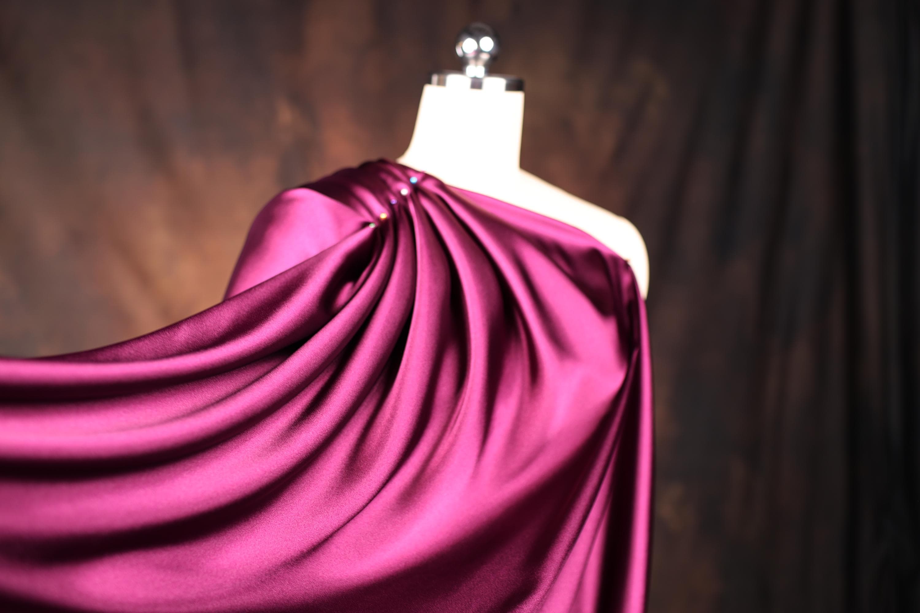 a dress on a mannequin with a purple cloth draped over it