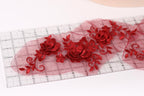 a close-up view of a clear ruler with red floral embroidery designs on it.