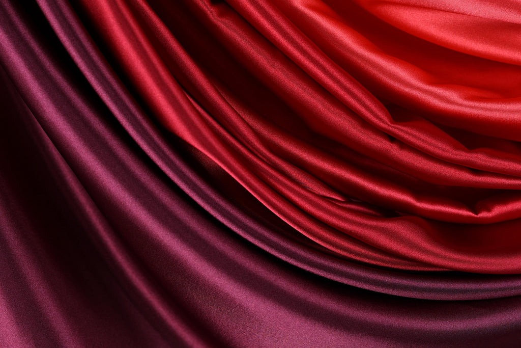 a close-up view of a fabric with a gradient of red and purple colors, creating a visually striking and vibrant appearance.
