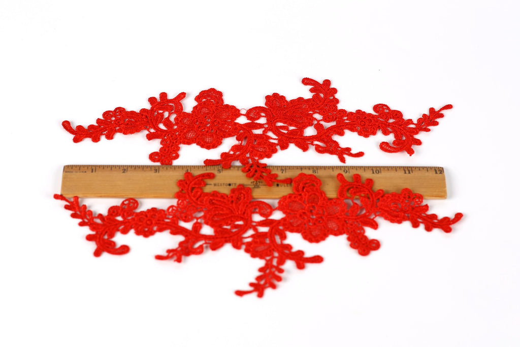 a pair of red lace pieces, each approximately 6 inches long, placed on a wooden ruler for size comparison.