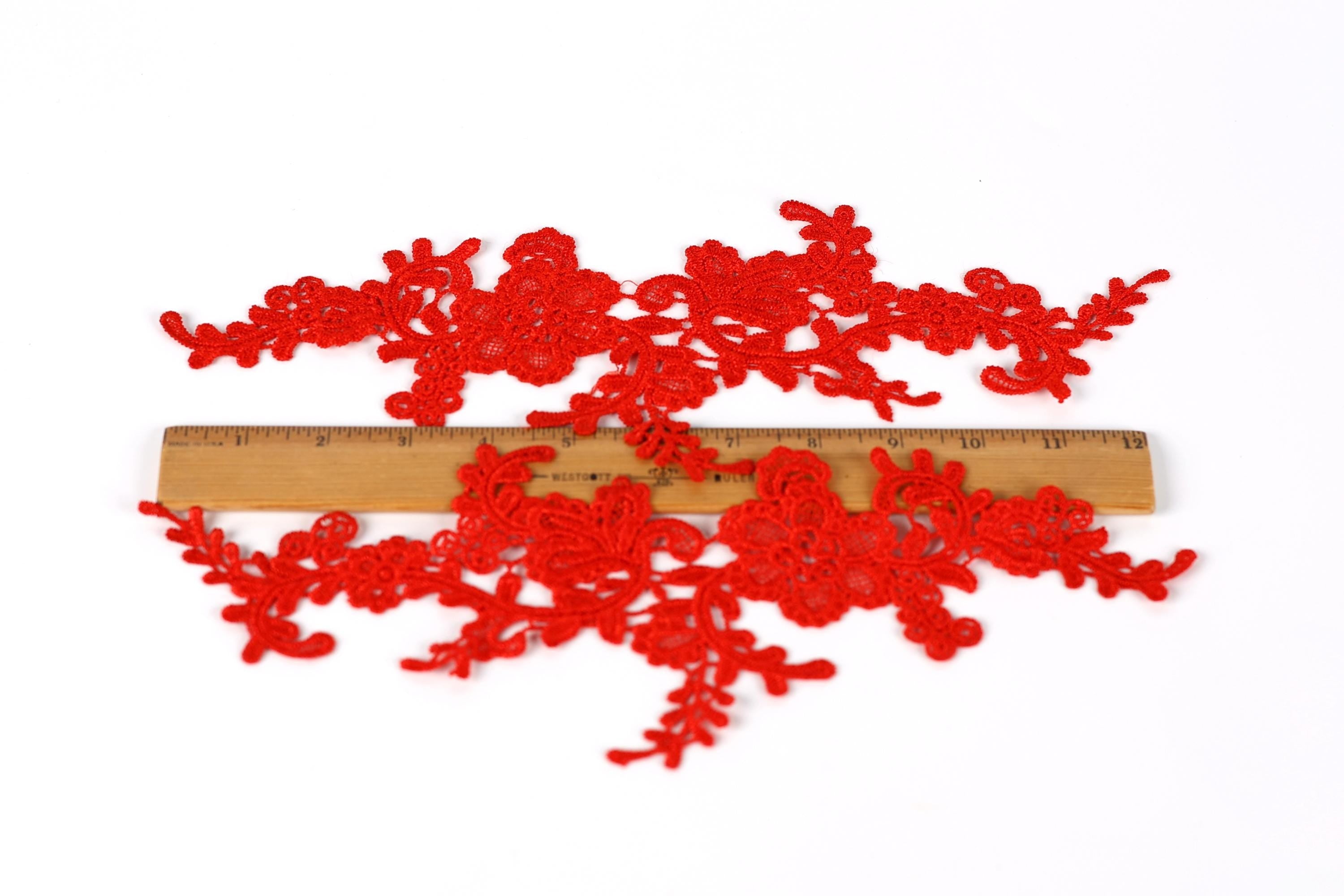 a pair of red lace pieces, each approximately 6 inches long, placed on a wooden ruler for size comparison.