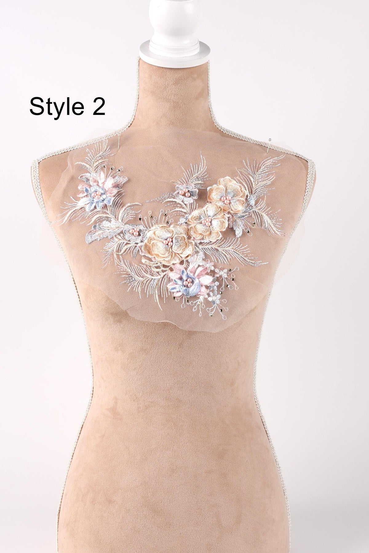A mannequin with a decorative floral embroidery on its bust area, featuring various types of flowers and foliage.