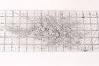 a close-up view of a decorative silver flower arrangement on a ruler.