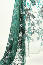 a close-up view of a fabric with a floral pattern in shades of green and black.