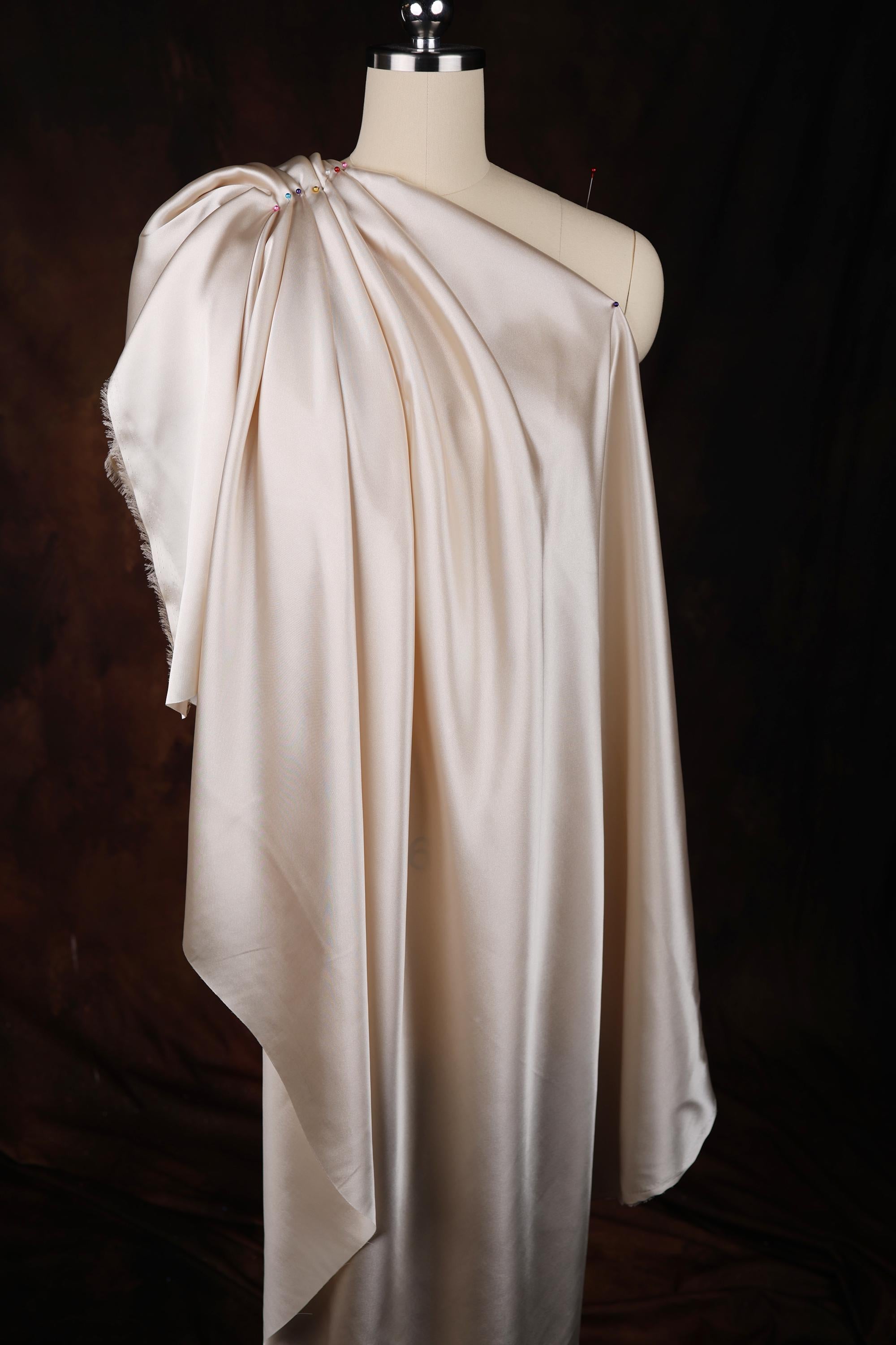 a mannequin with a white dress draped over it