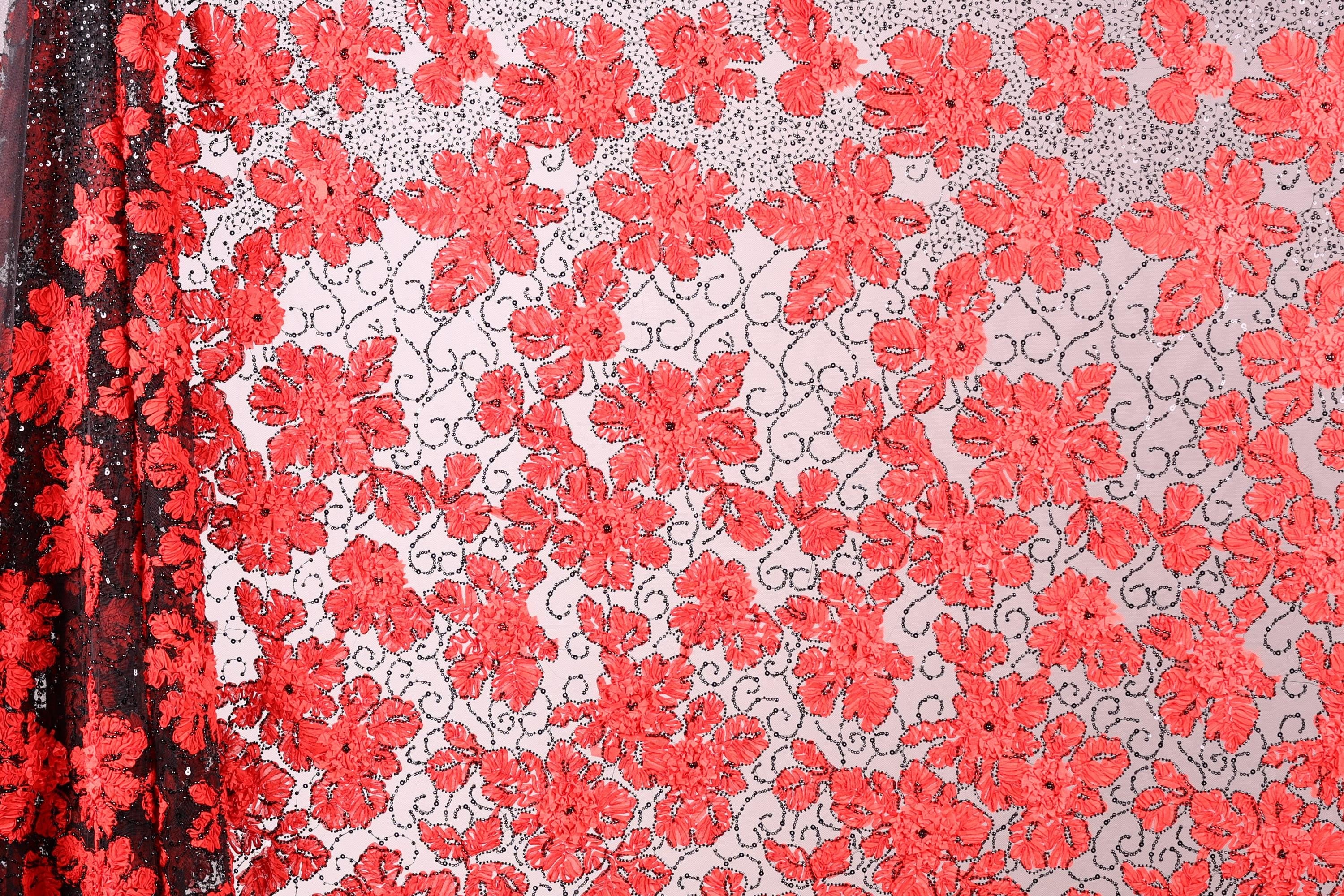 a close-up view of a fabric with a repeating pattern of red flowers on a white background. The flowers are arranged in a diagonal pattern, creating a visually striking contrast between the red and white colors. The fabric appears to be made of a sheer material, which adds a delicate and airy texture to the overall design.