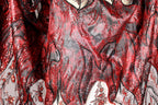 a close-up view of a fabric with a striking red and black pattern, featuring a mix of sequins and embroidery. The fabric appears to be a piece of clothing or textile, with the intricate design and vibrant colors creating a visually captivating scene.