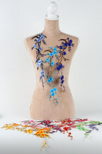 a mannequin with a floral design on its torso, including blue and purple flowers and branches.