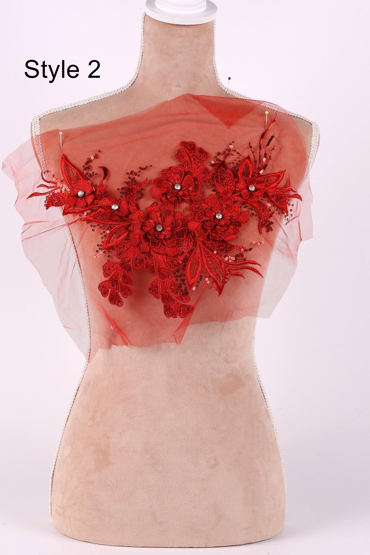 A mannequin with a red floral embellishment on its chest.