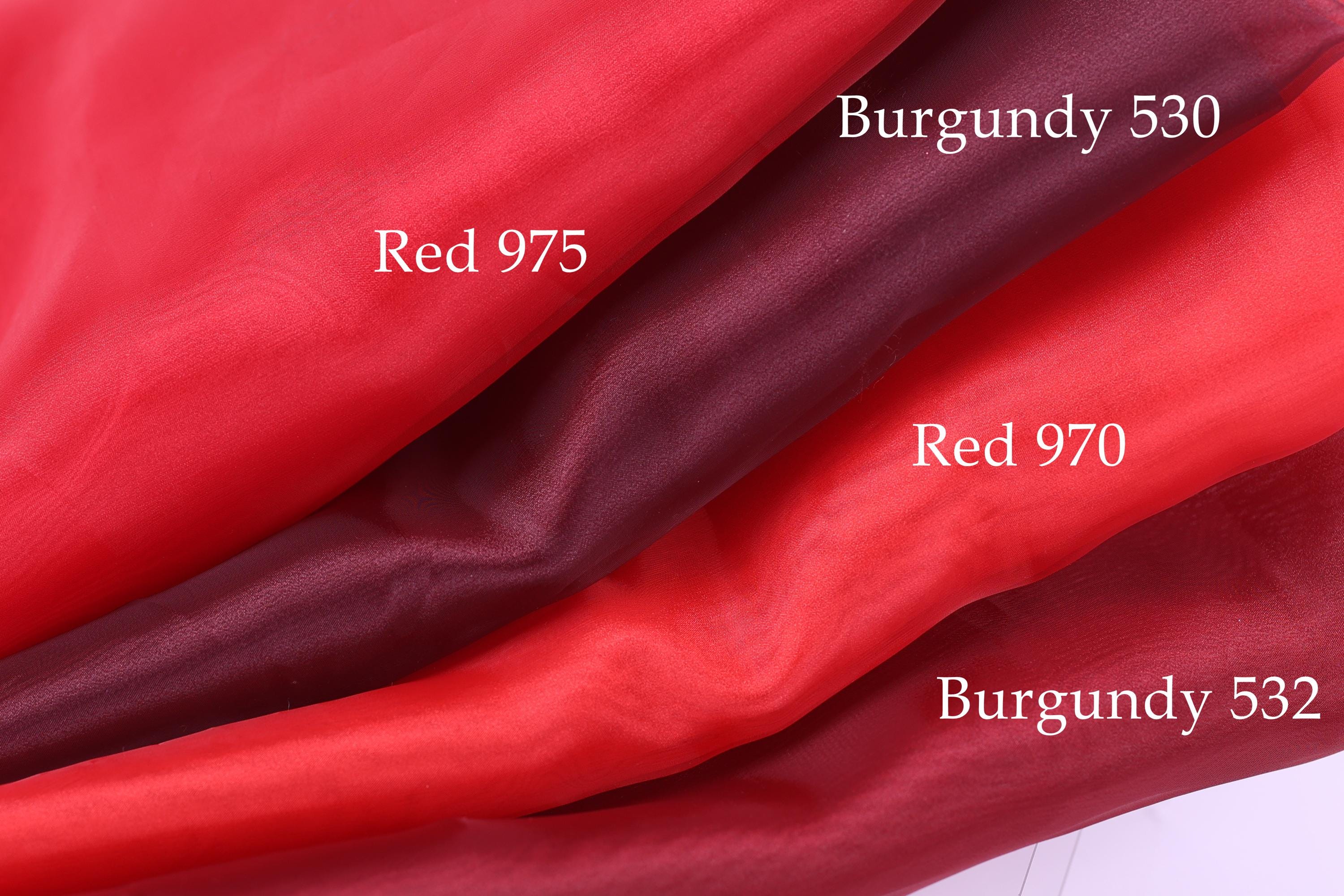 four different red fabric swatches, each with a label indicating the color and the fabric type.