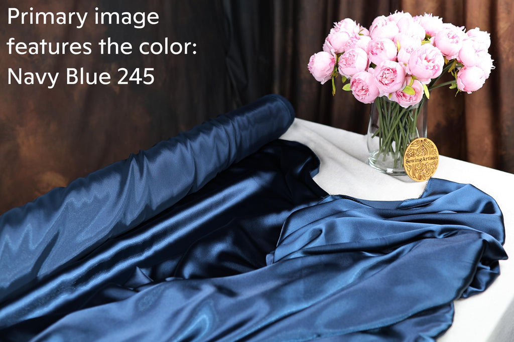 a navy blue fabric with a vase of pink flowers on a table, and there is a gold medal with text on the table.