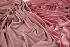 a close-up view of a crumpled, pink velvet fabric.