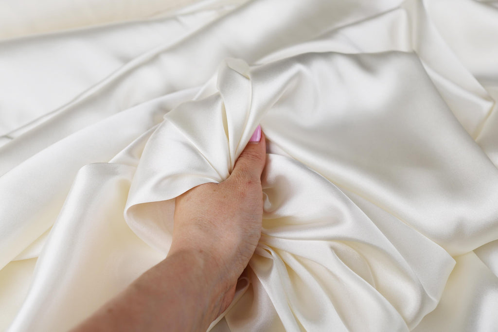 a person&#39;s hand on top of a white sheet