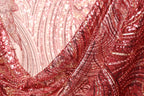 a close-up view of a fabric with a red and gold sequin pattern, creating a visually striking and intricate design.