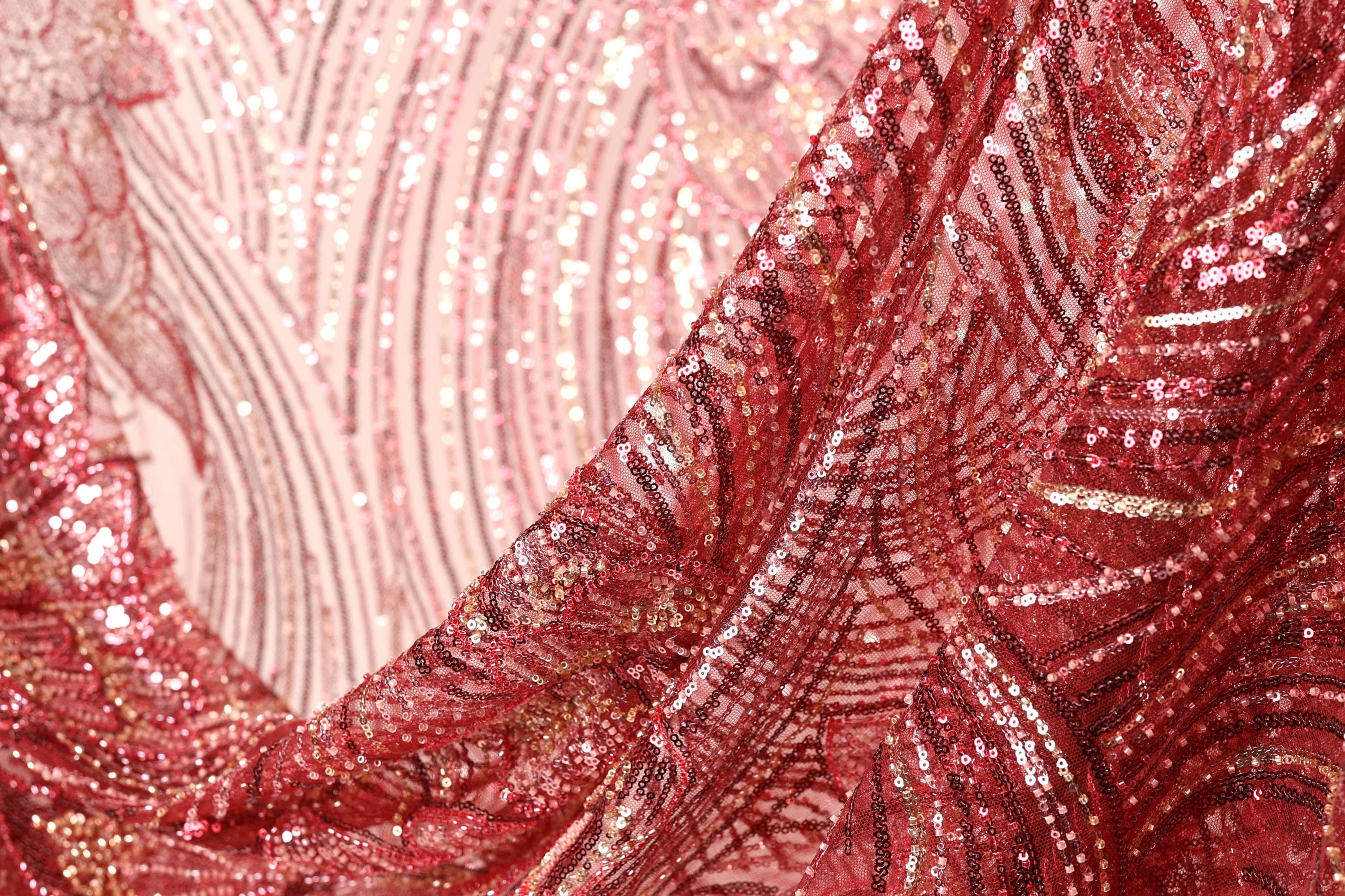 a close-up view of a fabric with a red and gold sequin pattern, creating a visually striking and intricate design.