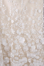 a close-up view of a delicate, white lace fabric with a floral pattern. The lace appears to be made of a soft, delicate material, possibly silk or chiffon, and is adorned with numerous small white flowers and leaves, creating a beautiful and intricate design. The fabric is spread out, allowing for a clear view of its texture and pattern.