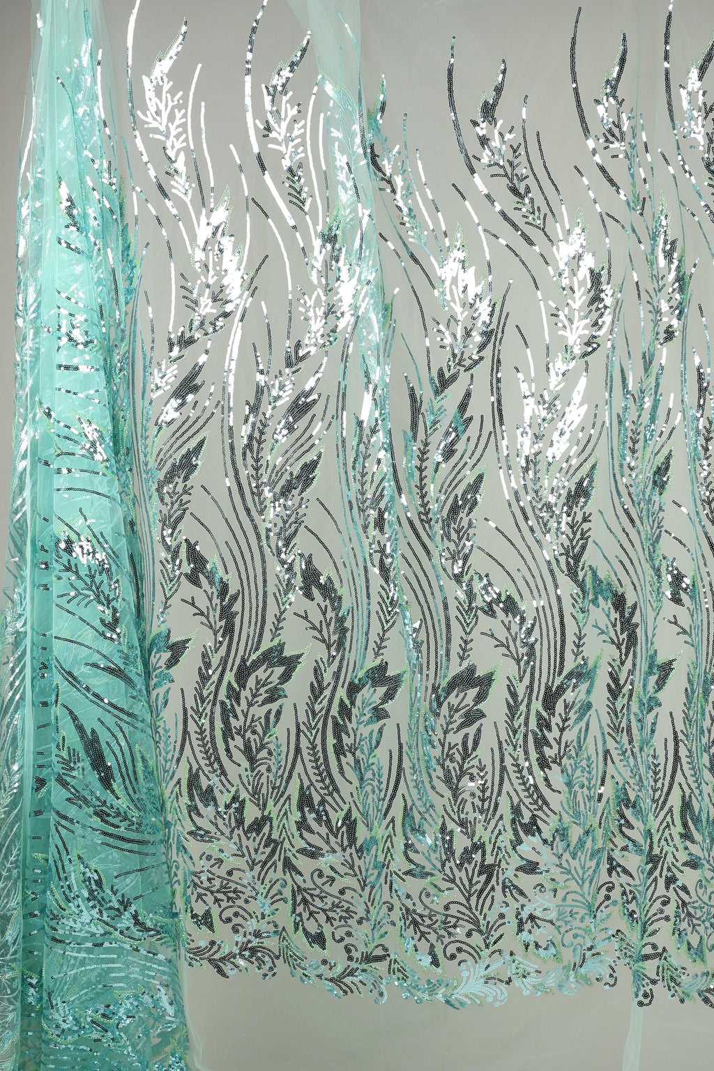 a fabric with a repeating pattern of black and white leaves and flowers, creating a visually striking and intricate design.