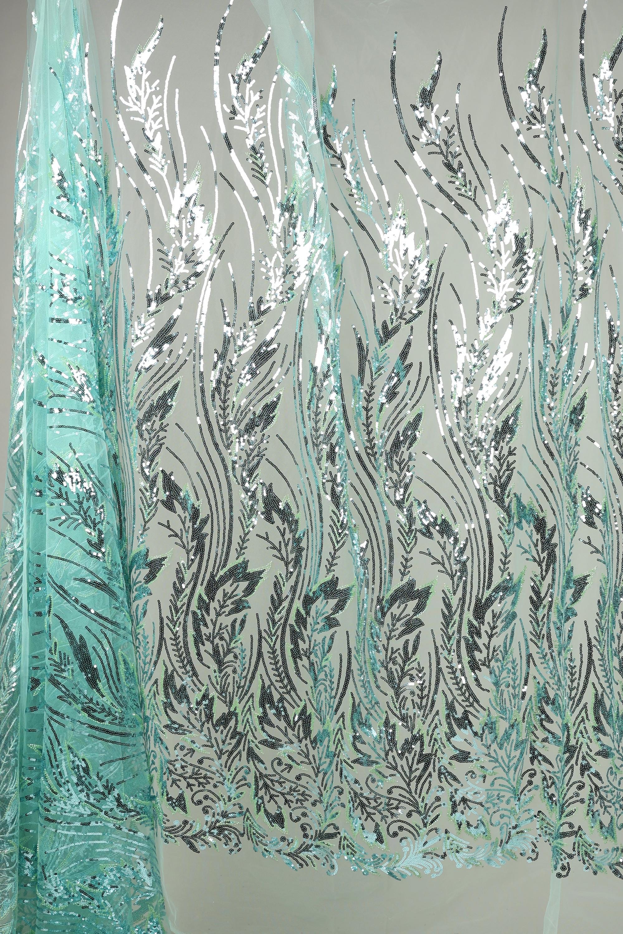 a fabric with a repeating pattern of black and white leaves and flowers, creating a visually striking and intricate design.