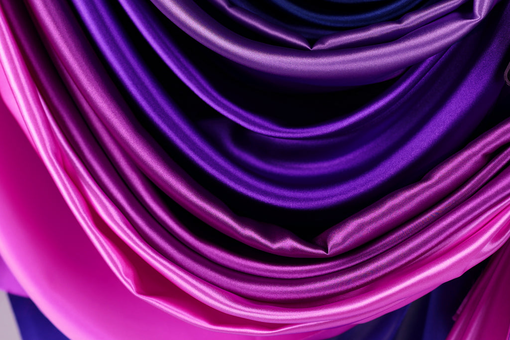a close-up view of a fabric with a gradient of purple and pink colors, creating a visually appealing and textured appearance.