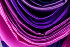 a close-up view of a fabric with a gradient of purple and pink colors, creating a visually appealing and textured appearance.