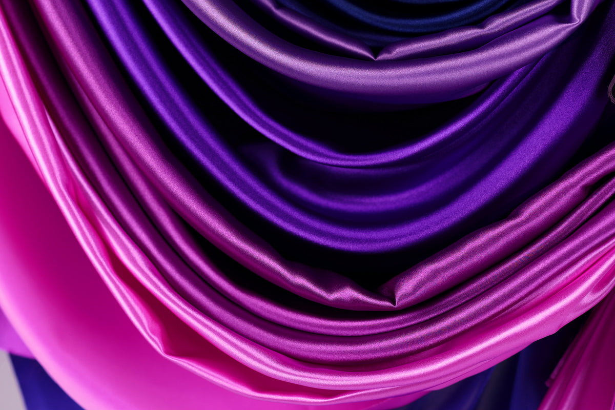 a close-up view of a fabric with a gradient of purple and pink colors, creating a visually appealing and textured appearance.
