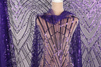 a mannequin wearing a purple sequin fabric with a sheer overlay. The fabric has a pattern of purple and black sequins, creating a visually striking and eye-catching design.
