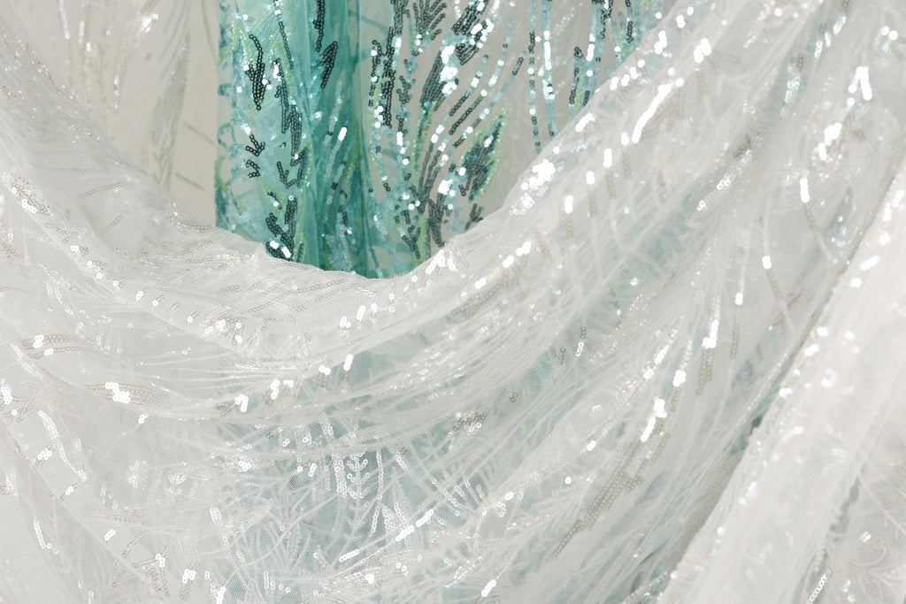 a close-up view of a white fabric with sequin patterns, creating a visually striking and intricate design.