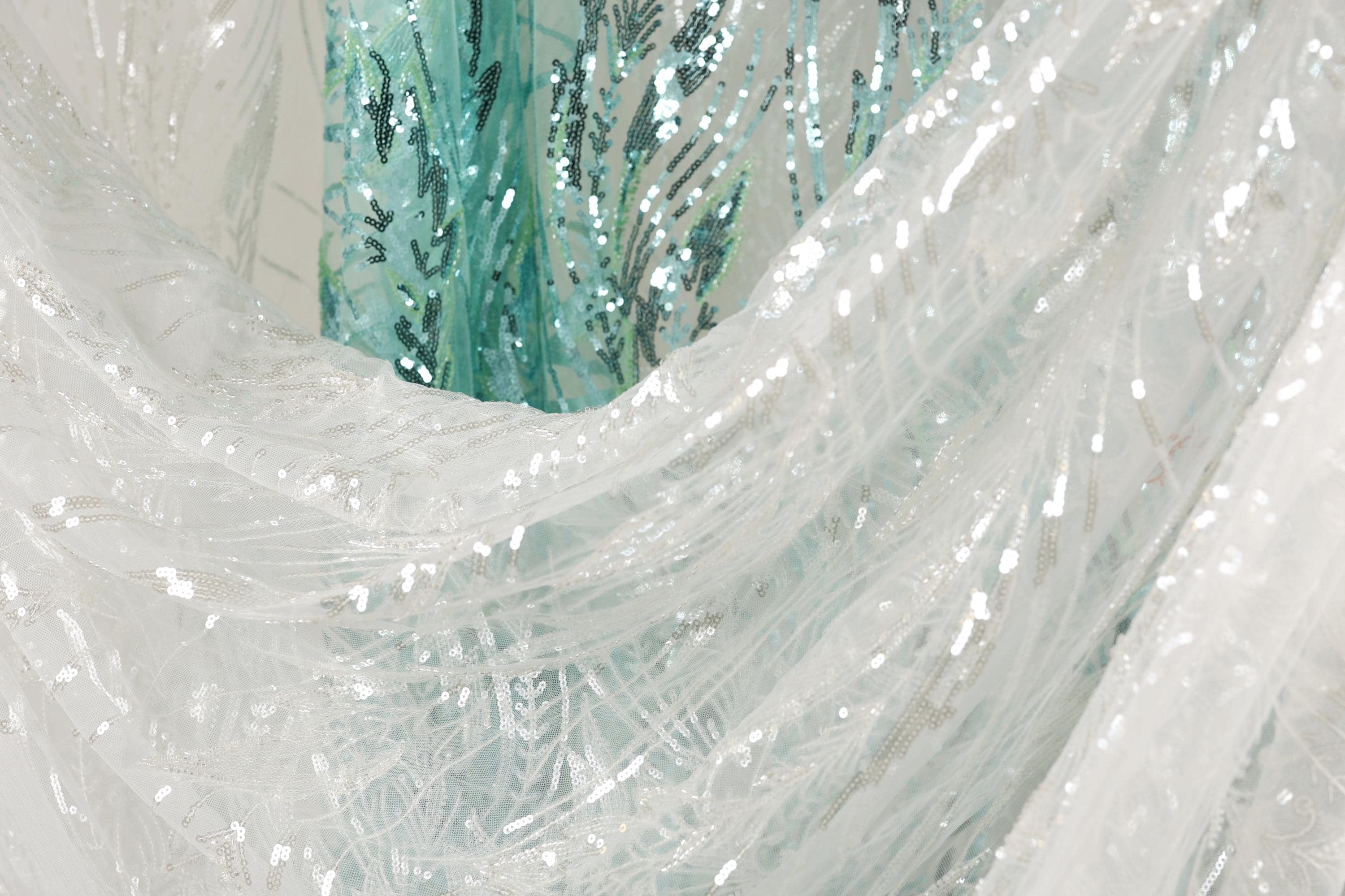 a close-up view of a white fabric with sequin patterns, creating a visually striking and intricate design.
