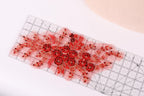 a clear ruler with a floral design on it, placed on a white surface.
