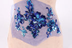a mannequin with a blue sequin floral design on its bust area.