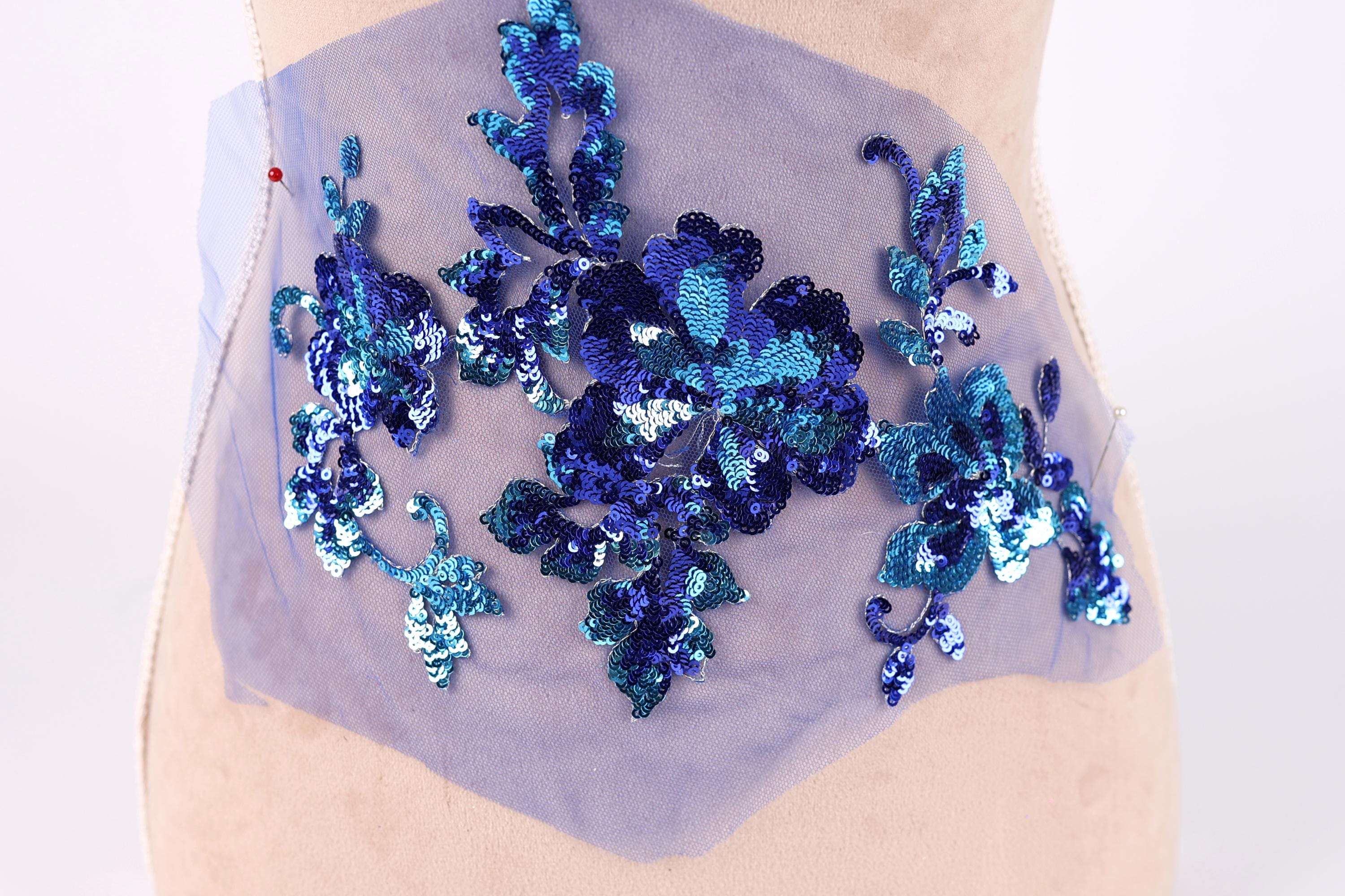 a mannequin with a blue sequin floral design on its bust area.