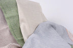 a close-up view of a fabric with horizontal stripes in various colors, including green, beige, and blue.