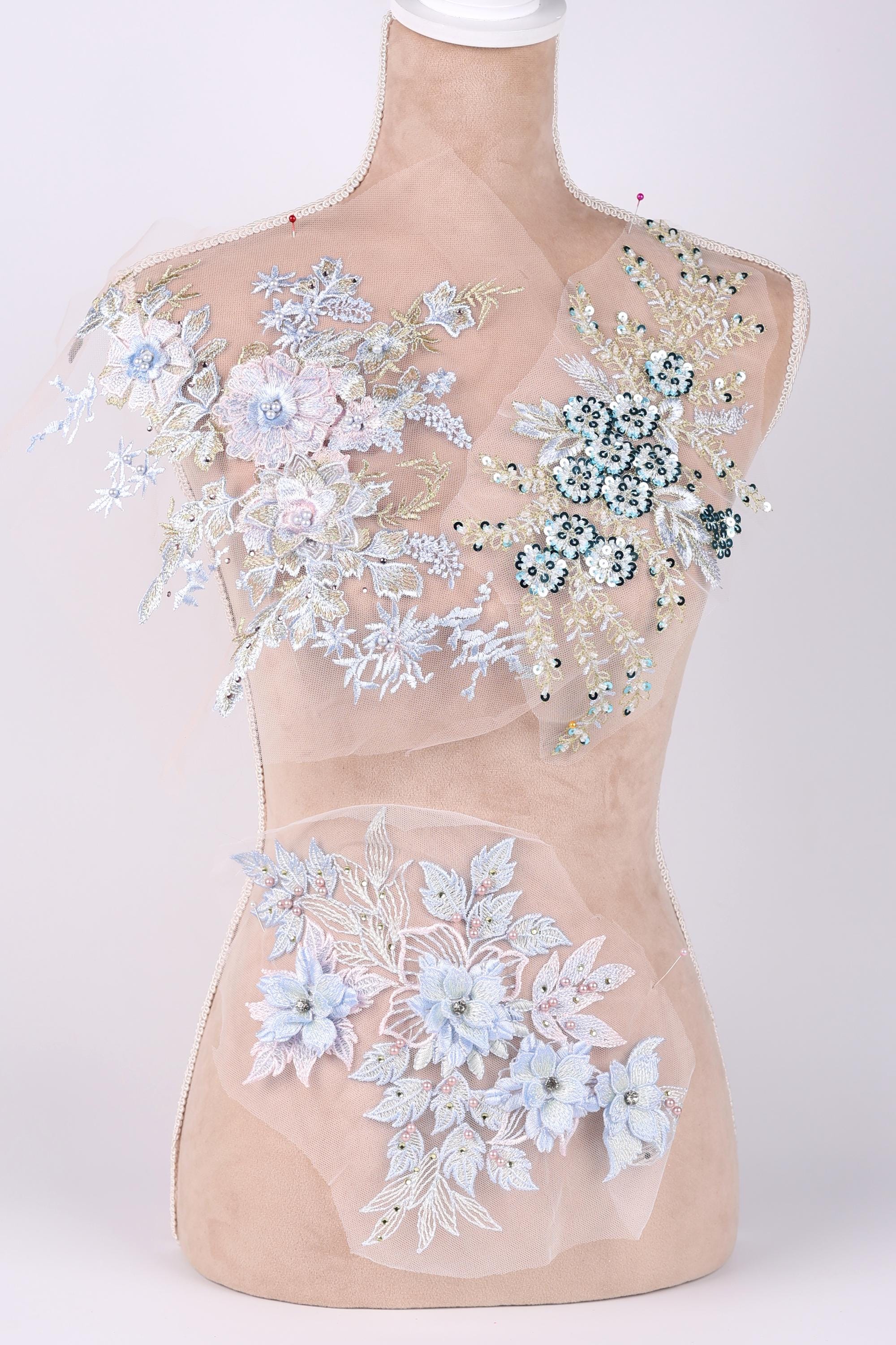 A mannequin with a beige body and a white bust form, adorned with intricate floral and leaf designs in shades of blue and white.