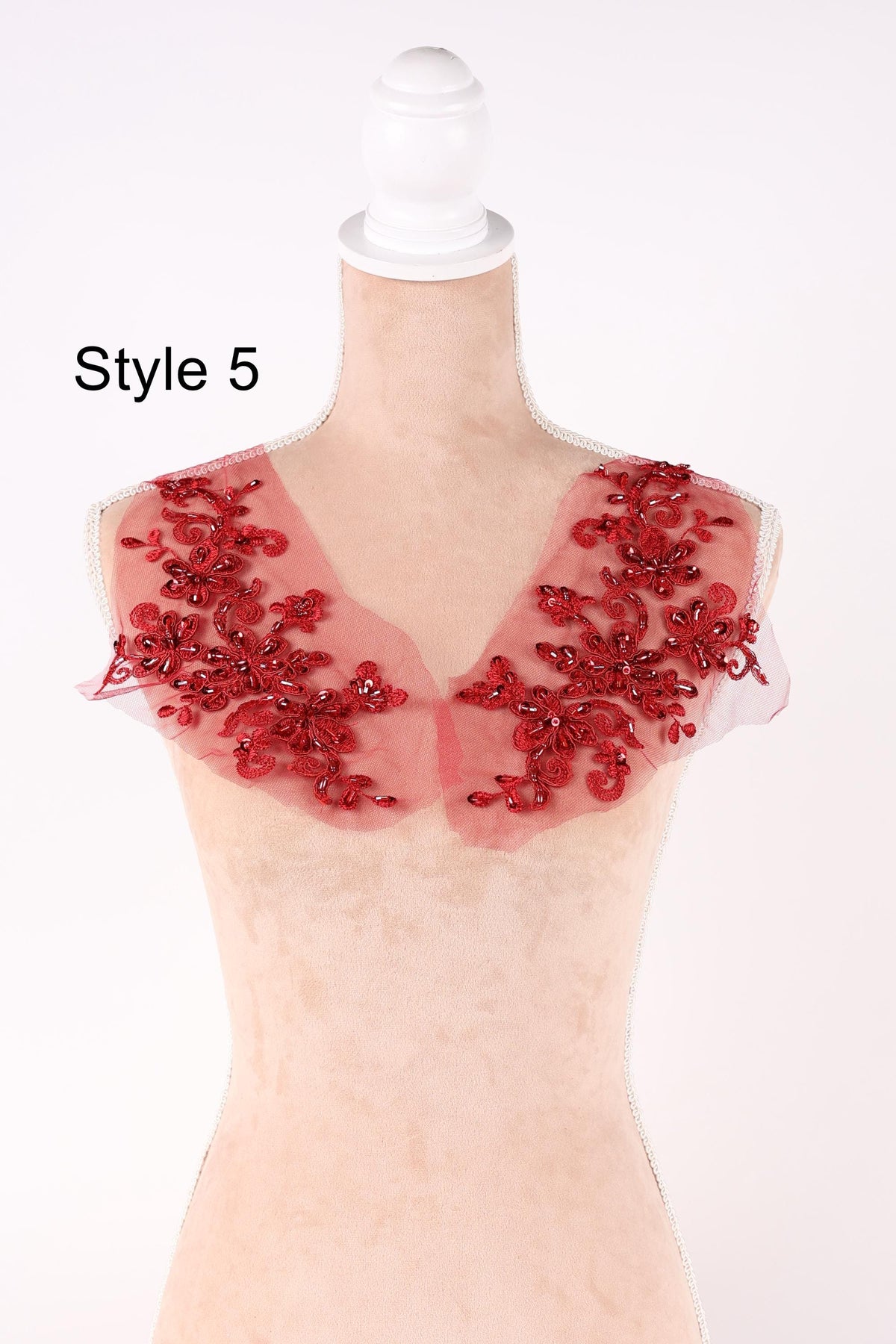 A mannequin wearing a red, floral-patterned fabric with a white headband.