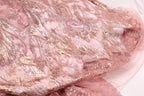 a close-up view of a pink and gold sequined fabric, with intricate patterns and designs.