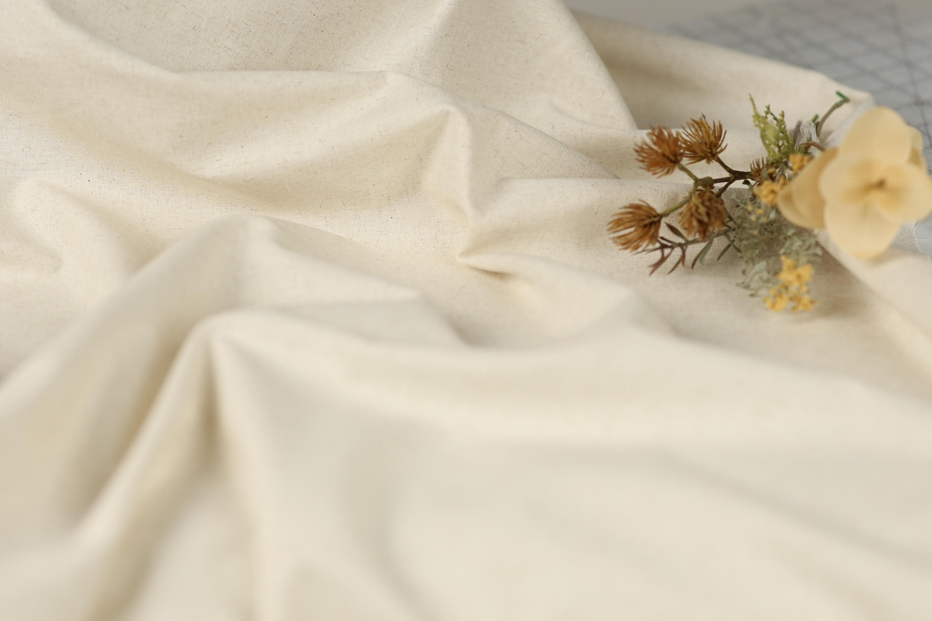 a close-up view of a white fabric with a small flower resting on it.
