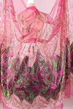 a pink and green dress with intricate embroidered patterns and sequins.