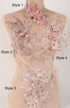 A mannequin with a beige dress adorned with intricate floral embroidery in shades of pink and white.